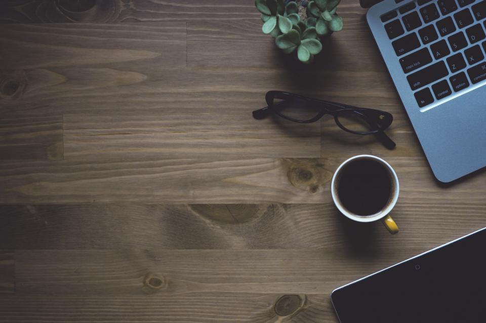 Schreibtisch mit Laptop und Kaffee als Symbolbild für die digitale E-Rechnung im Umzugsunternehmen