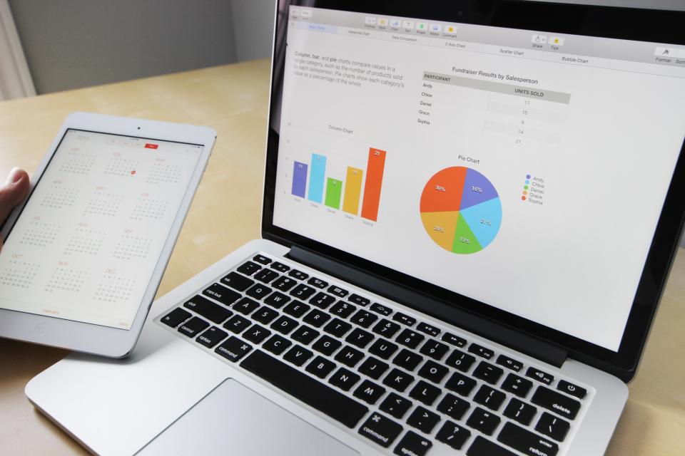 Laptop mit Tabellen und Diagrammen neben einem Tablet als Symbolbild Umzugssoftware gegen Excel